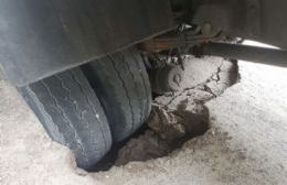 Un camión recolector quedó “encallado” en el enclenque pavimento de Avenida Génova