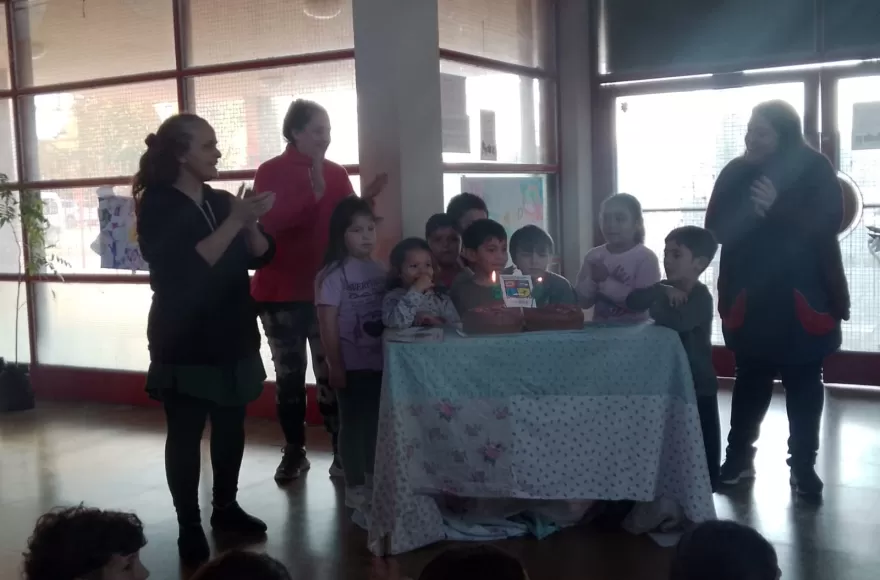 El grupo de los más chicos de la tarde, junto a docentes y directivos soplando las velitas.