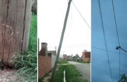 Poste de teléfono caído por el viento reposa sobre el tendido eléctrico