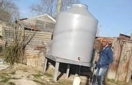 Vecinos cargan baldes de agua de un tanque para llevar a sus casas